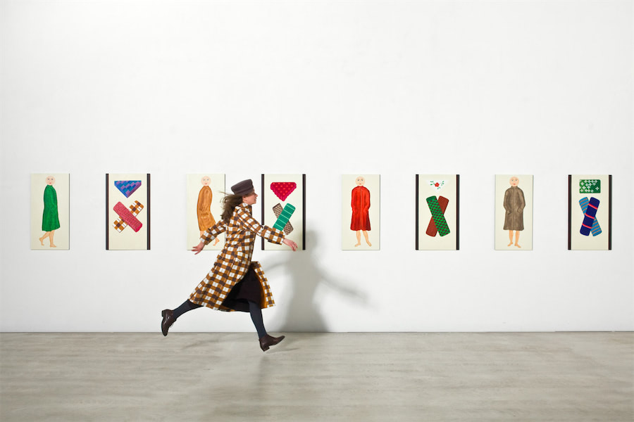 Frau läuft vor einer Bilderwand