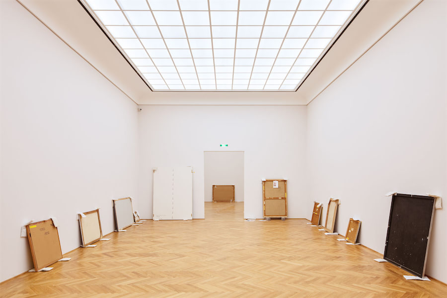 Bilder stehen in einer Ausstellungshalle